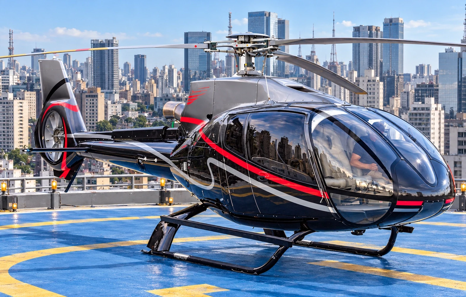 Helicóptero executivo em heliponto com o skyline de São Paulo ao fundo
